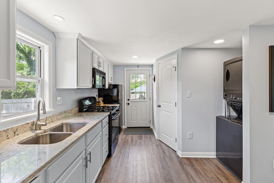 Kitchen, washer/dryer & door leading to fenced-in backyard