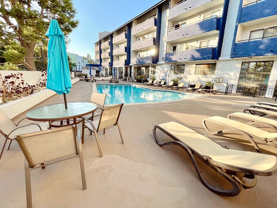 Pool with lounge chairs & outdoor dining tables.