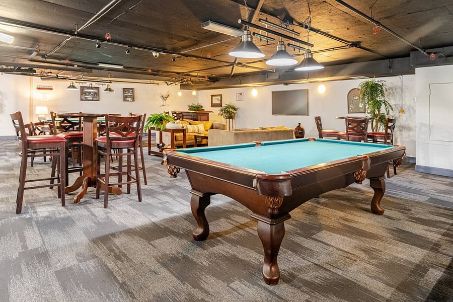 Spacious lounge with TV & sofa, bar & pub tables, and 2 pool tables.