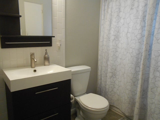 Bathroom features newer vanity and fixtures and also has subway tile shower surround as well as back splash for the sink.