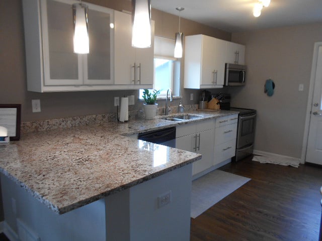 Kitchen features slab-granite counters, soft-close drawers, ample lighting and stainless appliances.  