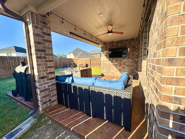 backyard patio with fan, table, furniture, and Smart TV