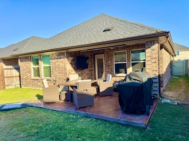 backyard patio with fan, table, furniture, and Smart TV