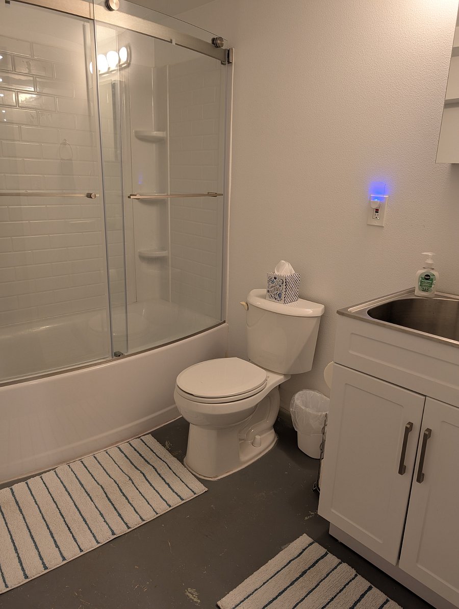 Shower/tub combo, toilet, mirrored medicine cabinet, large sink.