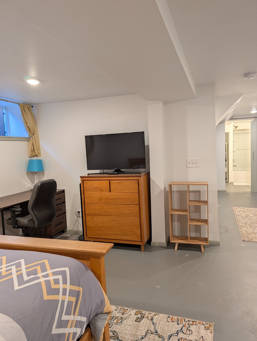 Smart TV, desk, chair, fan, dresser.