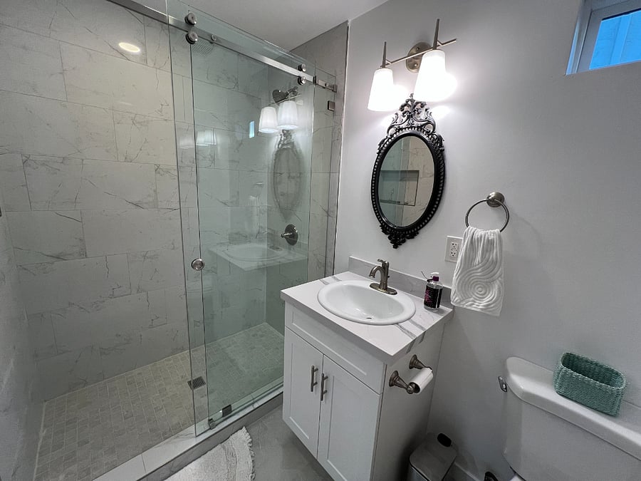 Bathroom with sink and vanity with storage underneath. Large shower with glass sliding doors for ease of access.