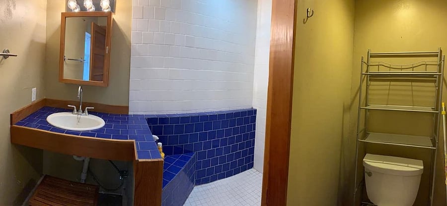 Panorama of the bathroom. Tile counters, walk-in shower with two showerheads, radiant heat in the floor.