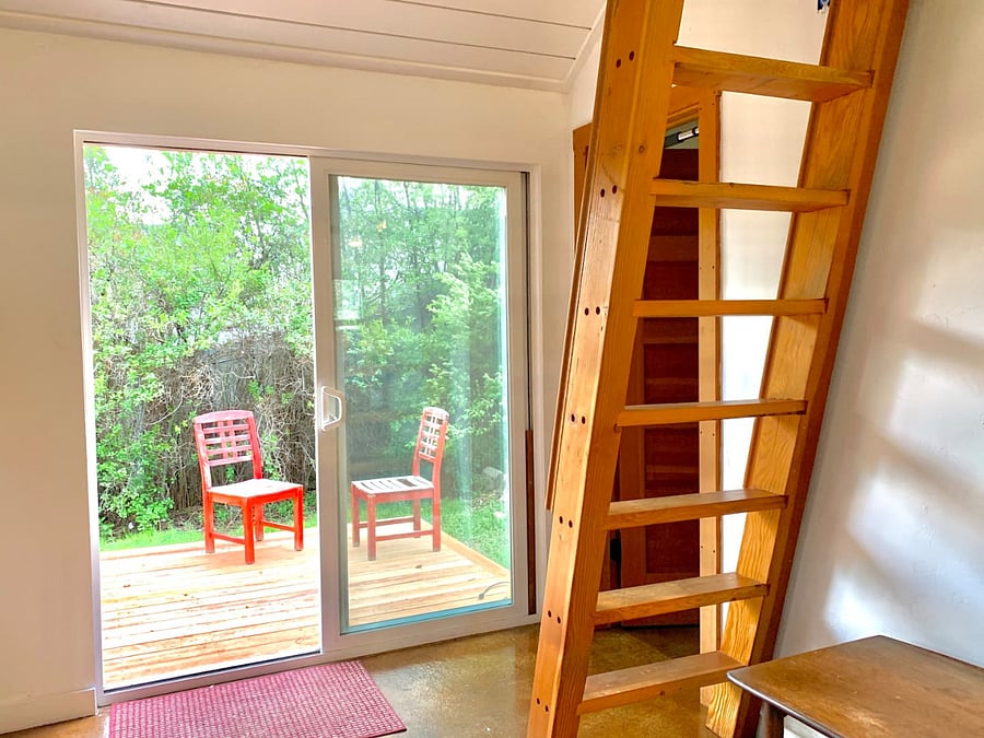 Patio door leading to the private deck. Ladder to the storage loft. Door to the bathroom, right.