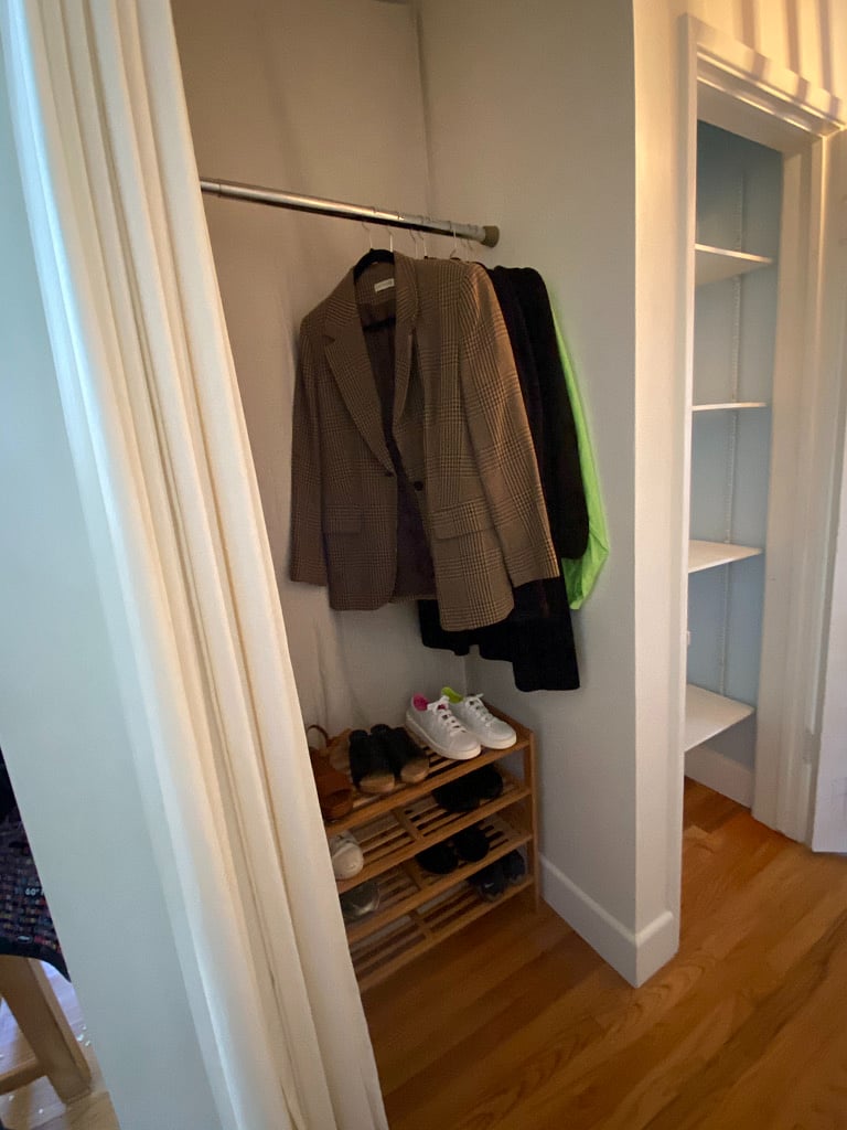 Hanging closet next to closet with shelves in hallway