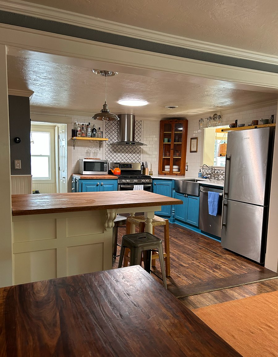 The living room and kitchen are connected by a butcher block island.