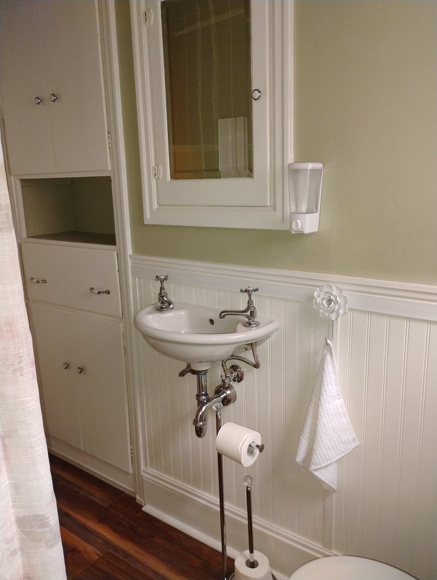 Cute 1920 vintage sink may not have a counter, but you don't need one with a hand sanitizer dispenser and hanging towel conveniently within easy reach.