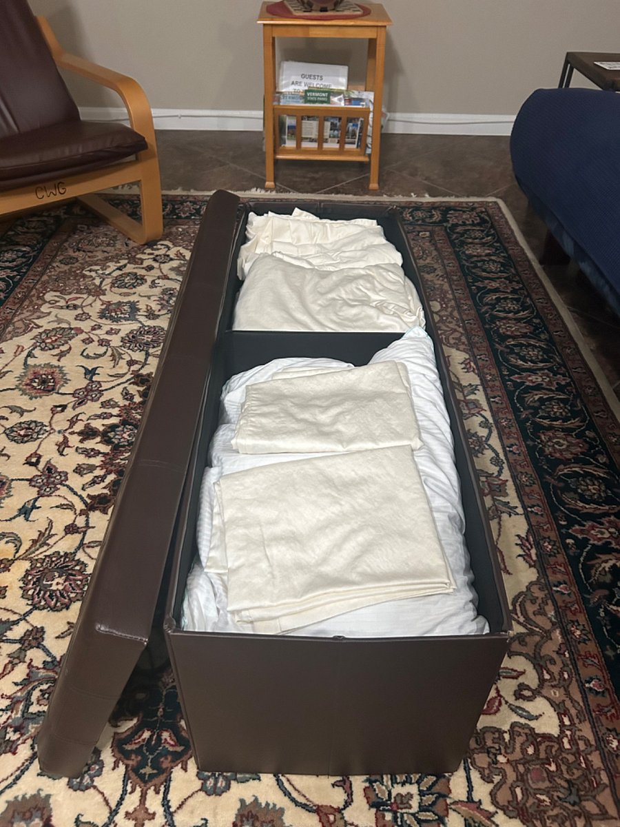 Ottoman for storage. Extra sheets, blankets and pillows for the occasional guest.
