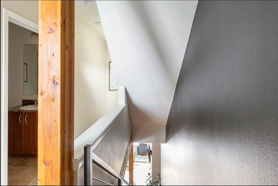 The stairwell leading upstairs to the washer / dryer unit and full shared bathroom