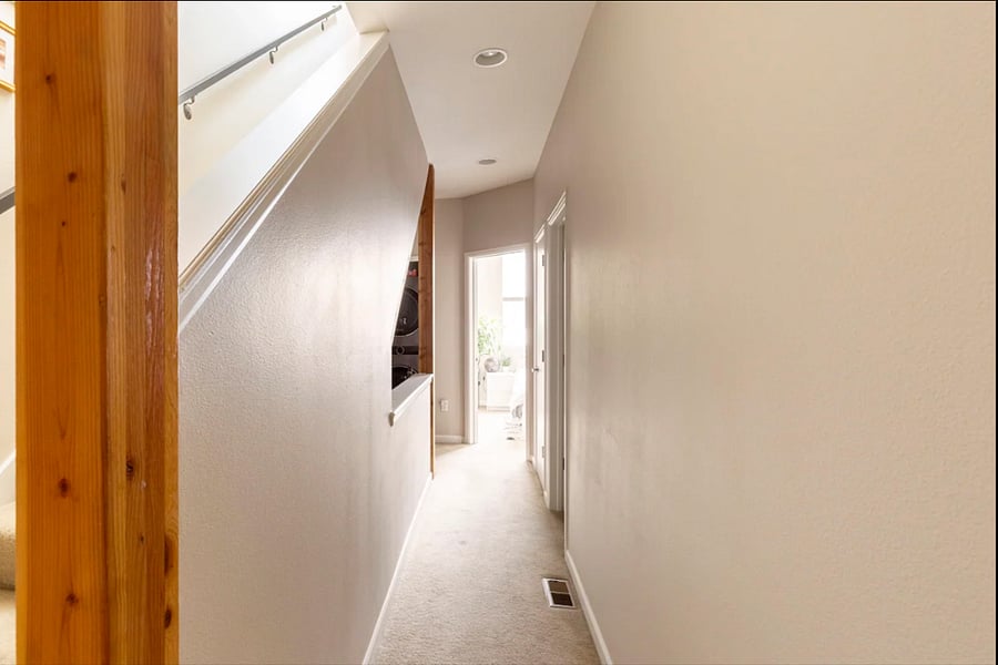 The upstairs hallway that connects the guest bedroom to the shared full bathroom.
