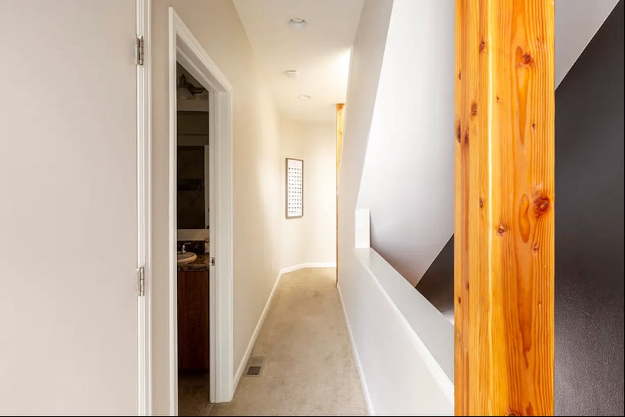 The upstairs hallway that connects the guest bedroom to the shared full bathroom.