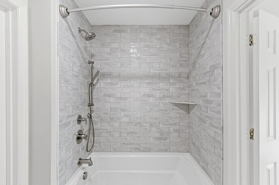 Tiled shower/tub that connects the two private vanities between the upstairs bedrooms. Toilet is also located here.