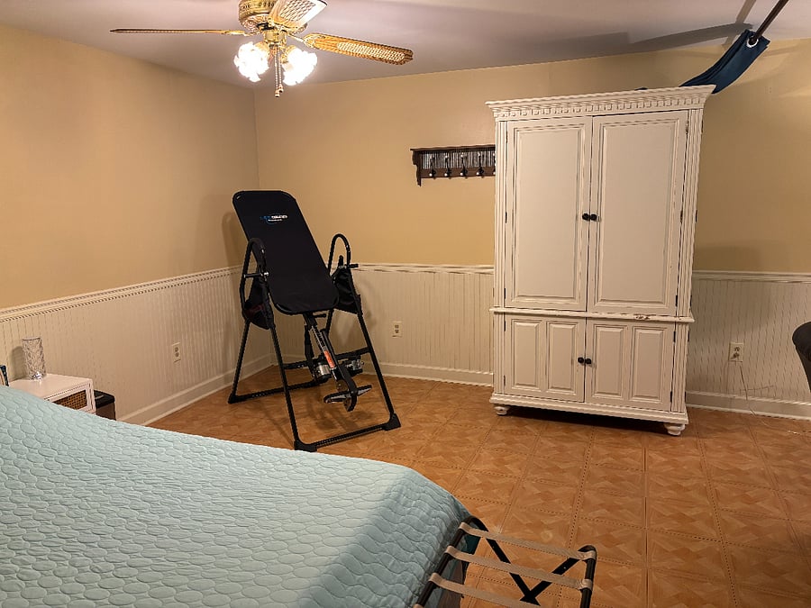 This area can be converted into a second bedroom once the navy black out curtains are drawn. There  is an inversion table,(use at your own risk and consult your doctor) but can be removed. WHAT'S AN INVERSION TABLE? This equipment is used for suspending oneself upside down or at an inverted angle to POTENTIALLY relieve back pain and improve spinal health. Also available are hooks for jackets, towels, purses ect. 
