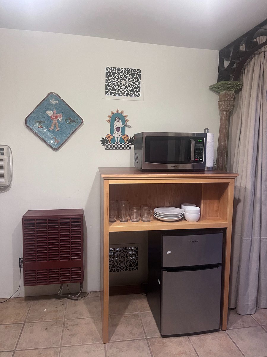 Cozy Kitchenette with mini-fridge, microwave, and basic dishware, perfect for quick meals. Decorated with local art, the space is inviting and ideal for traveling professionals. Conveniently Located near UNM School of Medicine, hospitals and restaurants.