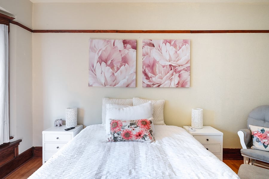Queen bed with nursing rocker and window seating.