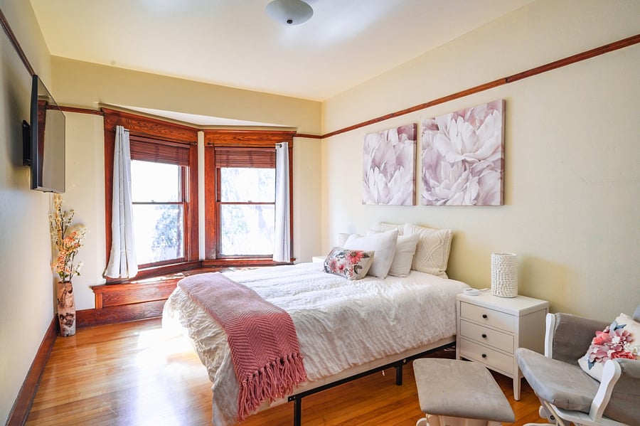 Queen bed with nursing rocker and window seating.