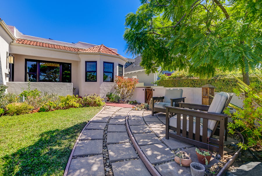 Fully enclosed front yard with seating and fountain.