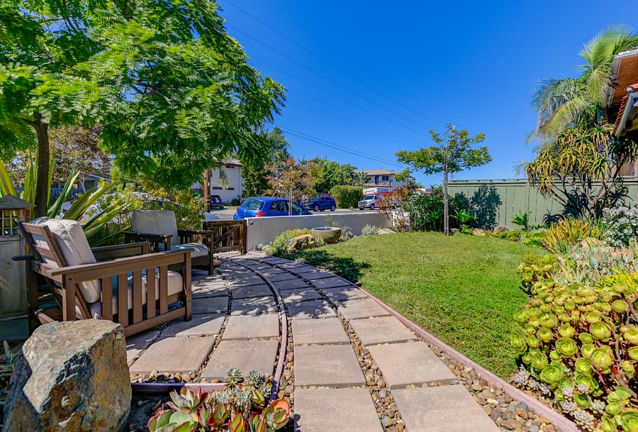 Fully enclosed front yard with seating and fountain.