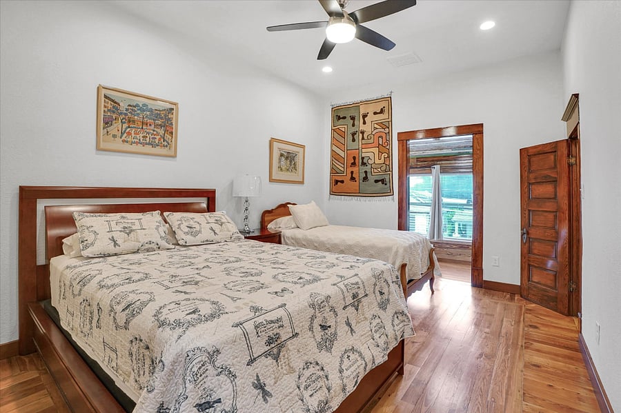 Bedroom #4. Queen bed and twin bed. Upstairs. This bedroom has it's own private full bath and an exit that leads down to the driveway. It also has access to the 2nd floor front porch. A twin bed could possibly be added in this room.