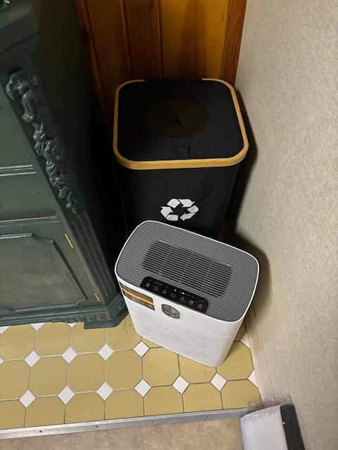 Recycle bin and air purifier. Under the recycle bin, there is a dryer vent that is duct taped over. The washer and dryer were previously where the green buffet is. 