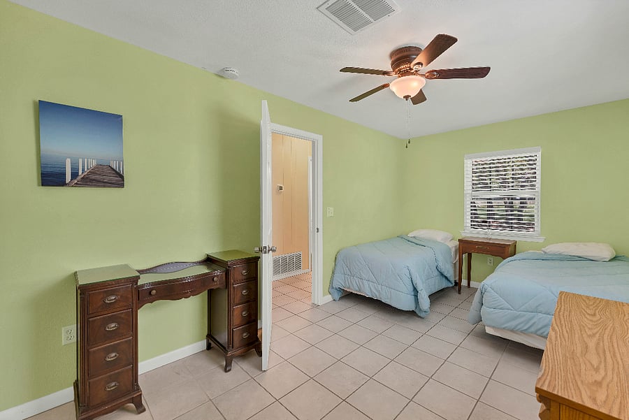 Bedroom includes two twin size beds. Includes a vanity, nightstand with drawers and dresser for extra storage.