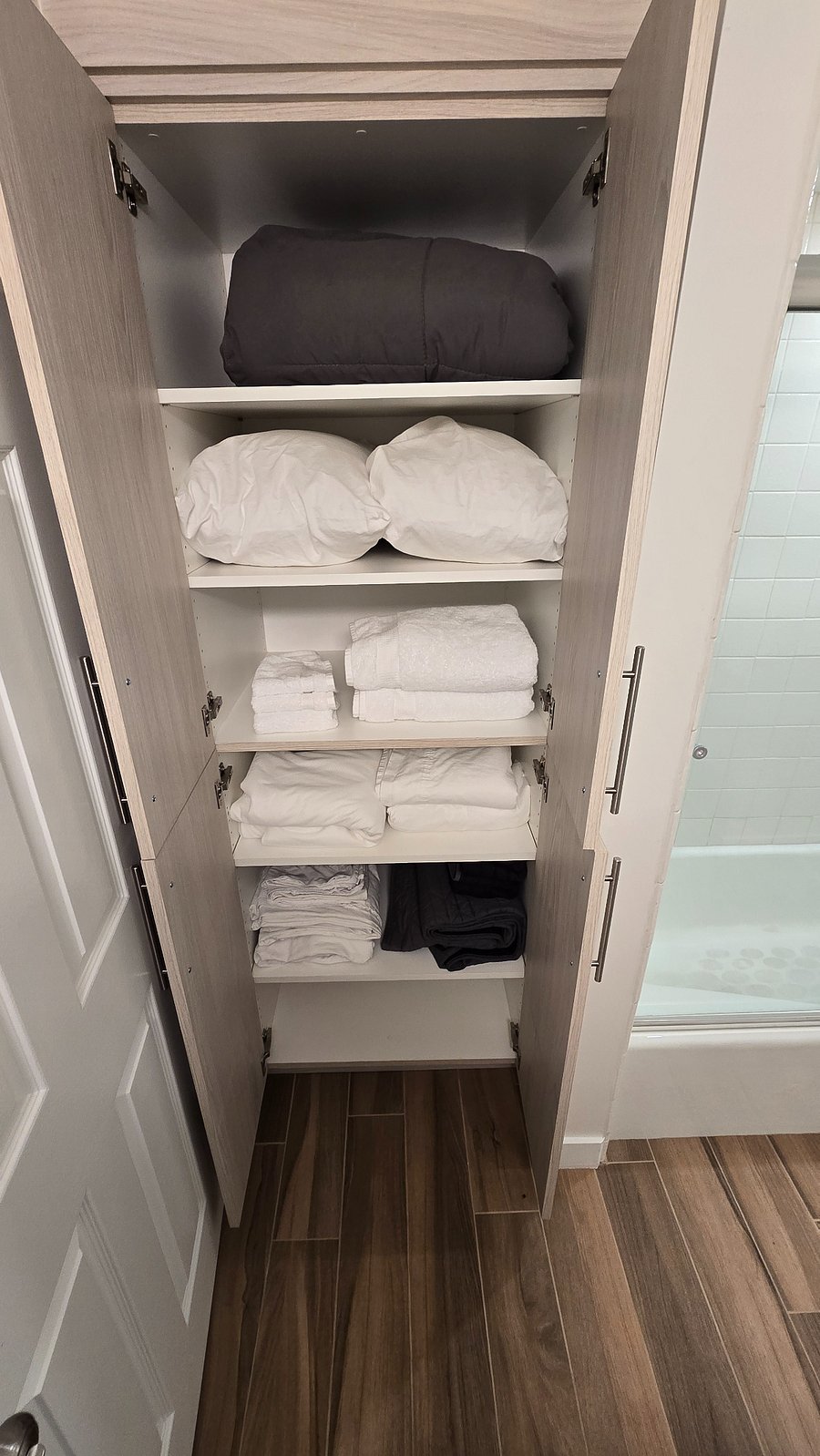 The bathroom closet has ample plush towels and sheets.