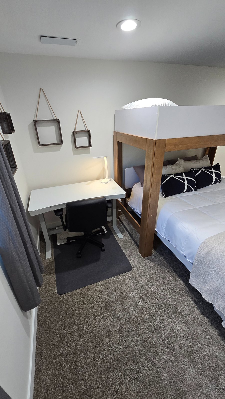 Powered standing and sitting desk (which includes a wireless charging pad and USB ports) with a desk lamp, chair and standing pad.