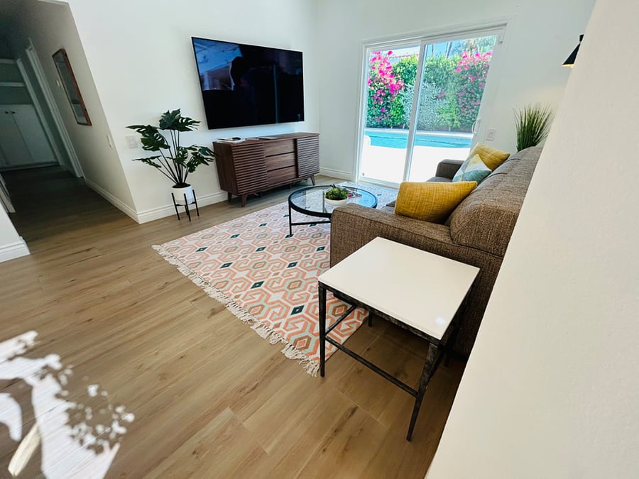 Casual living room with large flat screen TV and pool views!