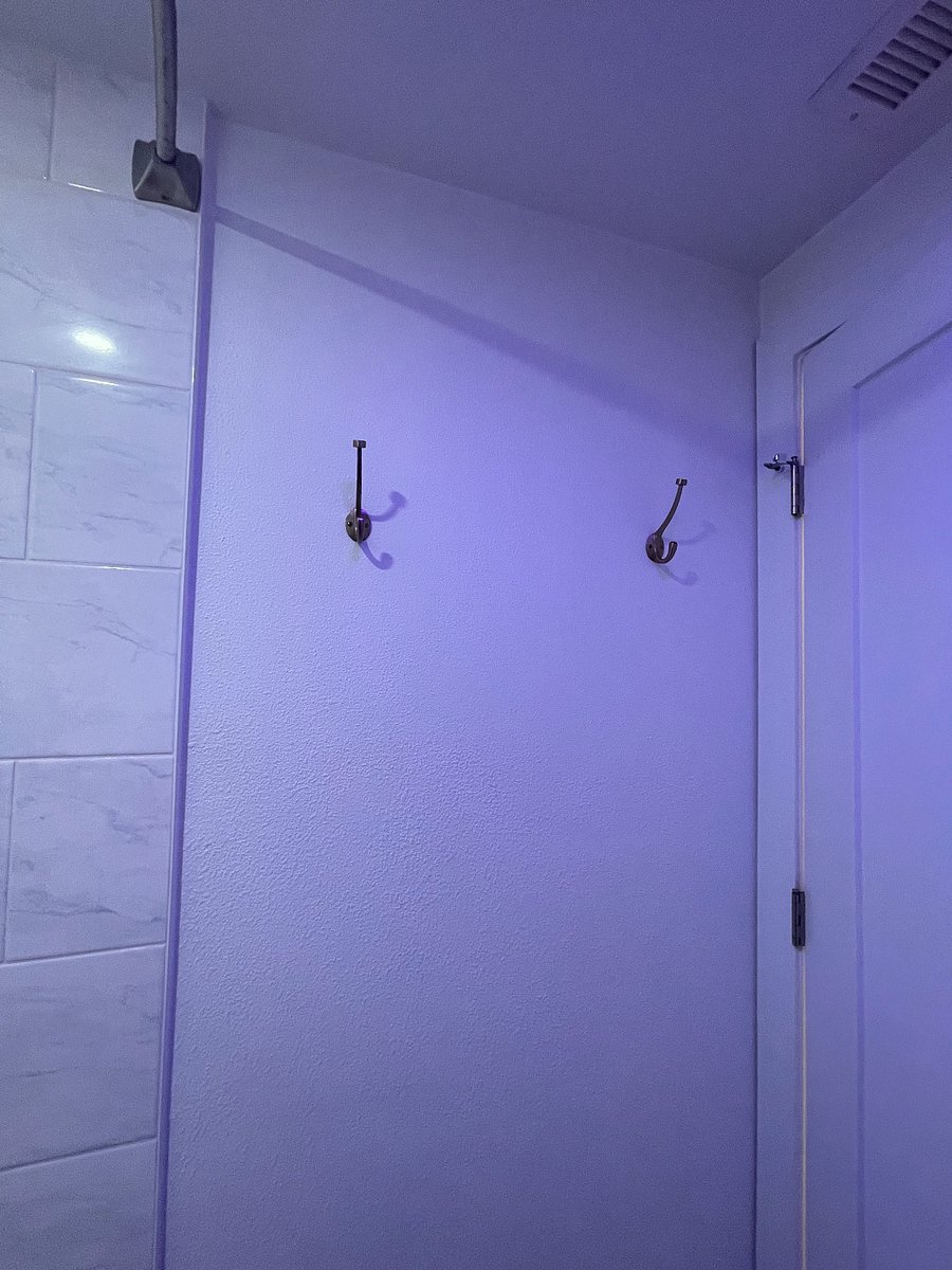 brass hooks behind the door for robes and towels