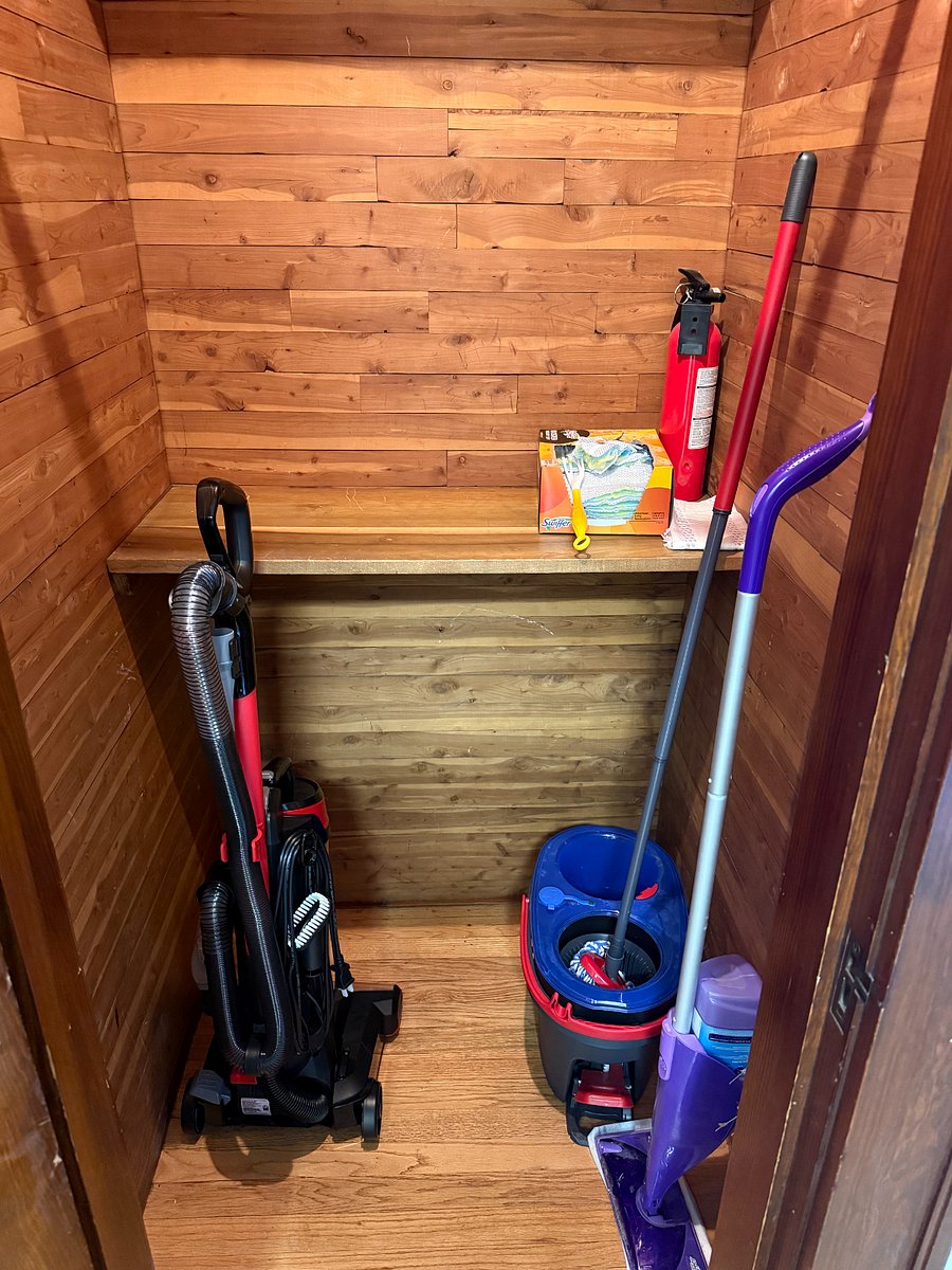Cedar plank closet with vacuum, Swiffer, and broom provided.