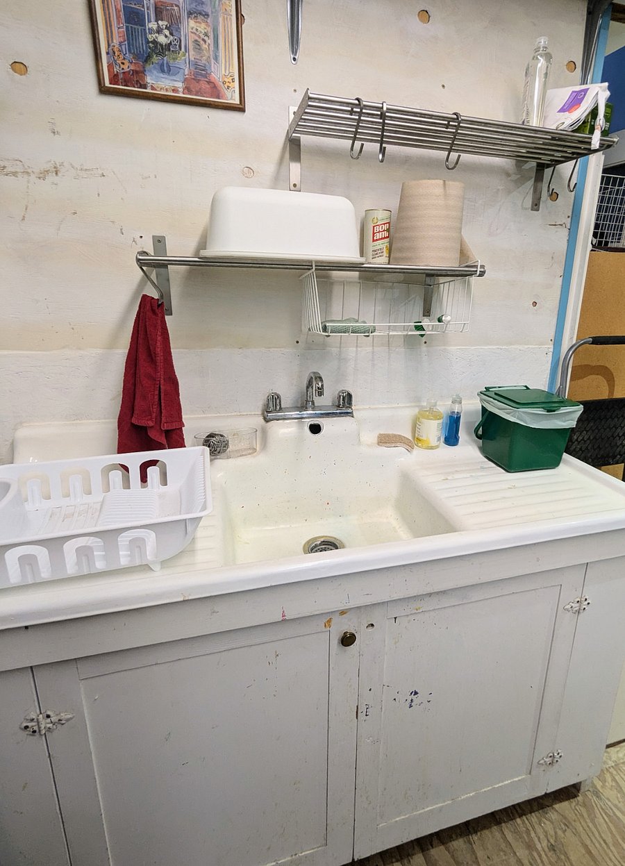 Utility sink for dishes, located a few steps from the bathroom