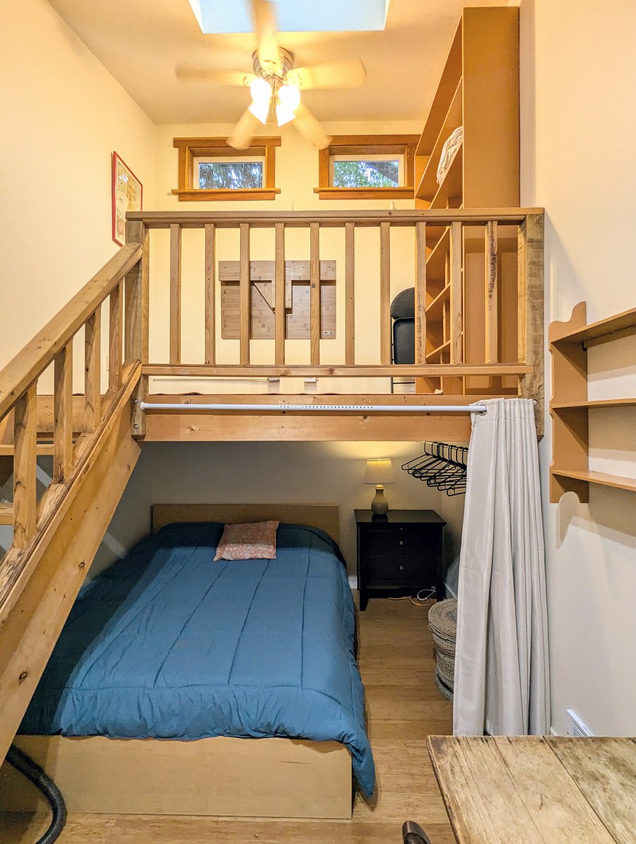 Loft with plenty of storage, comfortable Queen size bed beneath with nightstand dresser + lamp