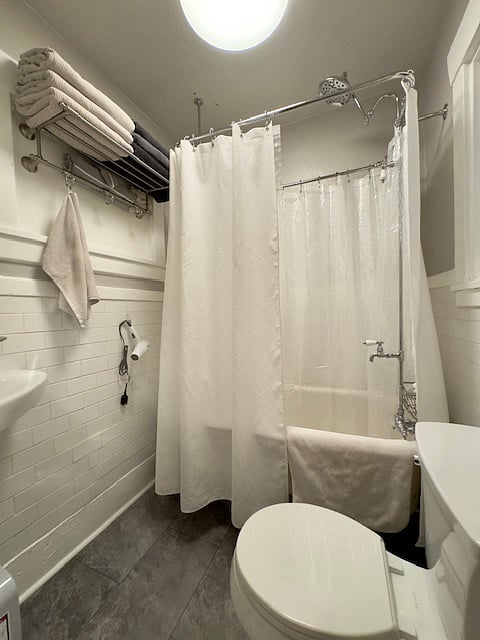 Claw foot bathtub with full shower.