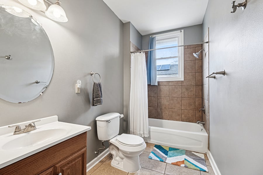 The full bathroom features plenty of storage, with an un-pictured storage closet and a bathtub.