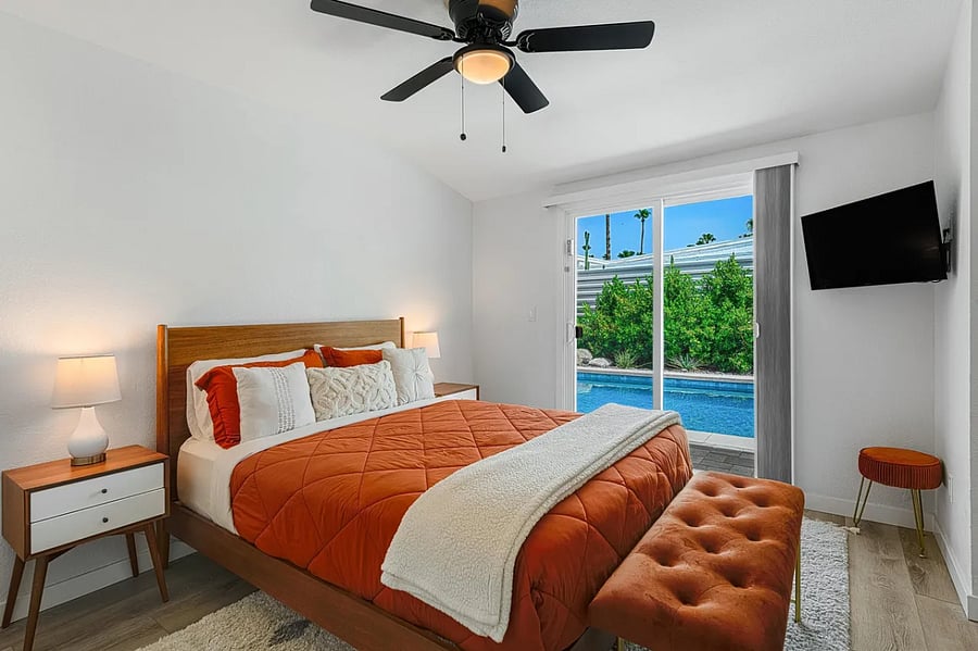 The primary bedroom features a plush queen bed and ensuite bathroom with a sleek standing shower.