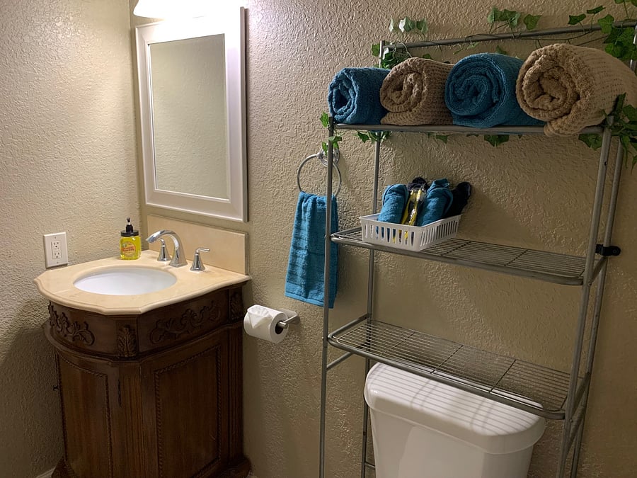 The second bathroom: hand soap, shampoo, conditioner, body wash, bath towels, hand towel, washcloths, slippers, tissue, toilet paper