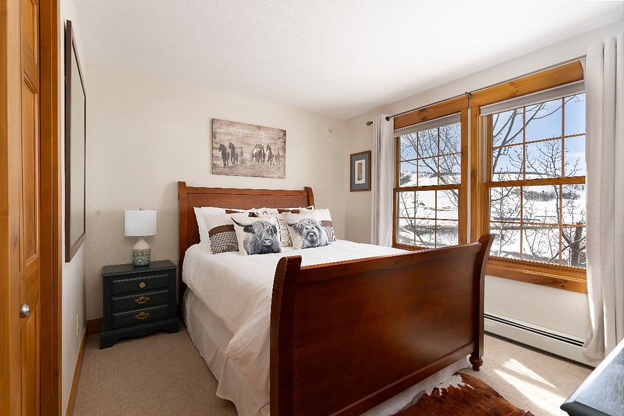 Upstairs secondary bedroom with queen bed, closet, dresser, and smart TV.