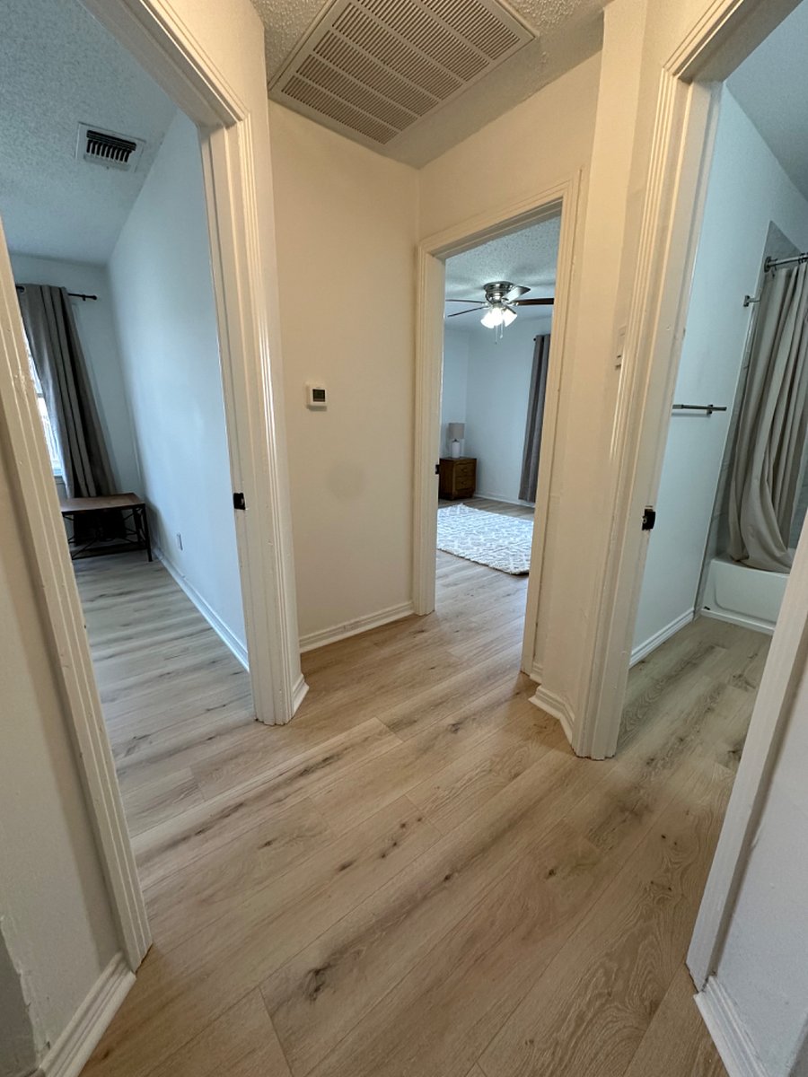 view of hallway that shows the two bedroom door and bathroom door