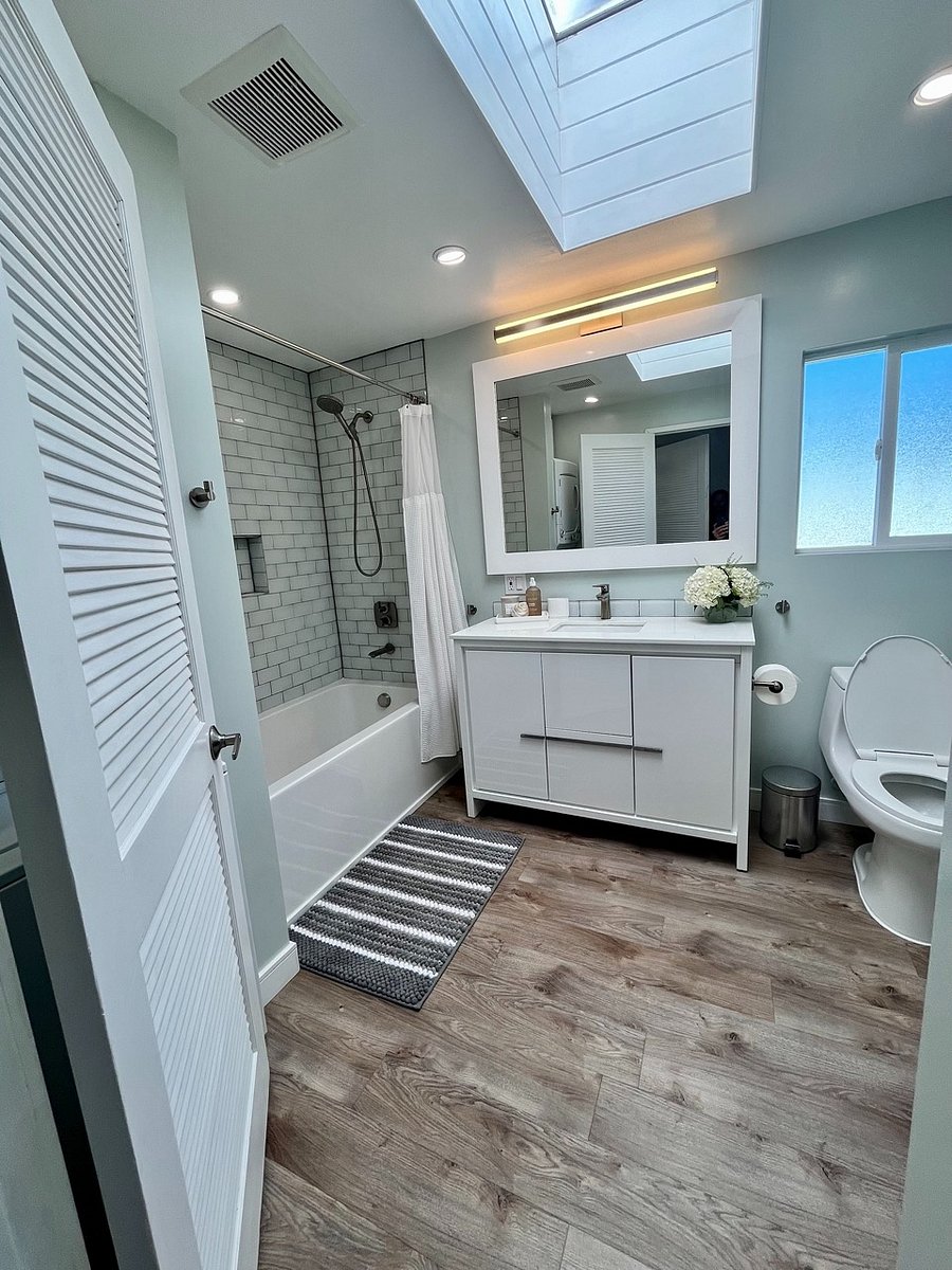 Bathroom with shower-bath  combo.
Well-lit with natural light from sky-light, recessed and vanity lighting.