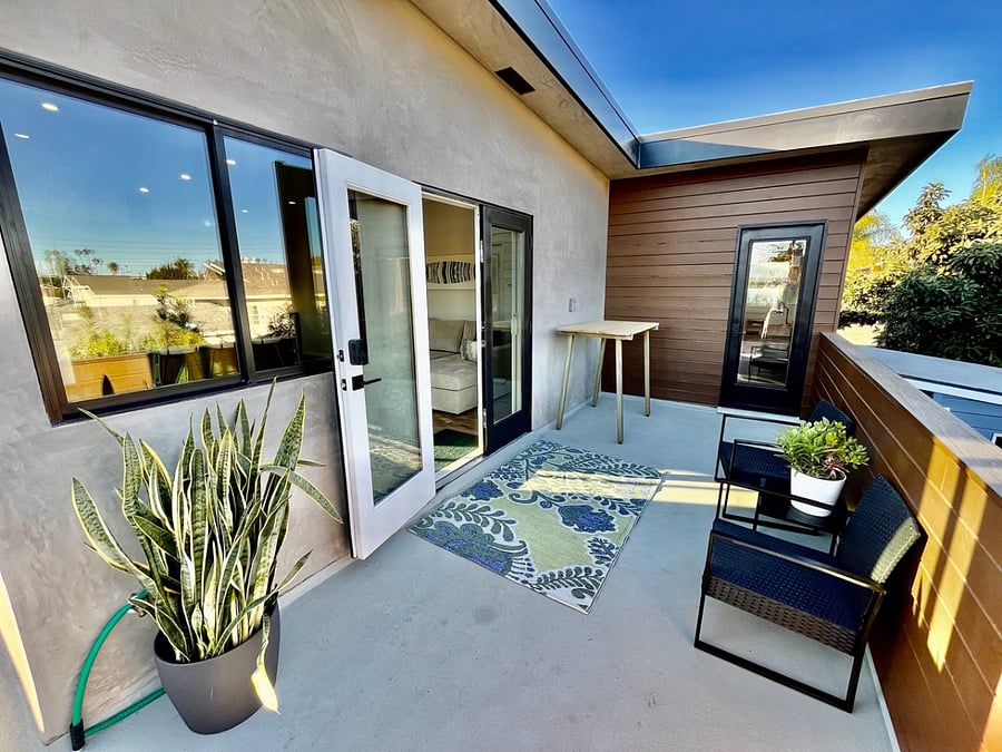 Private balcony with outdoor seating and dining. French doors open into the living area, another door leads to the office.