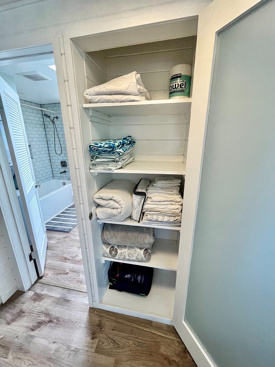 Linen closet with extra linens, blankets, beach towels, shopping bags, space for storage.