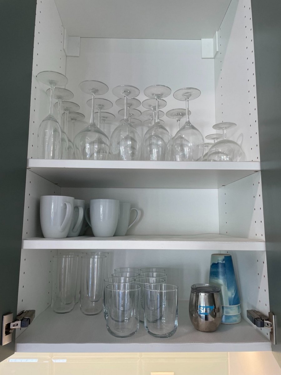 Dishes, glasses and stemware in fully stocked kitchen.