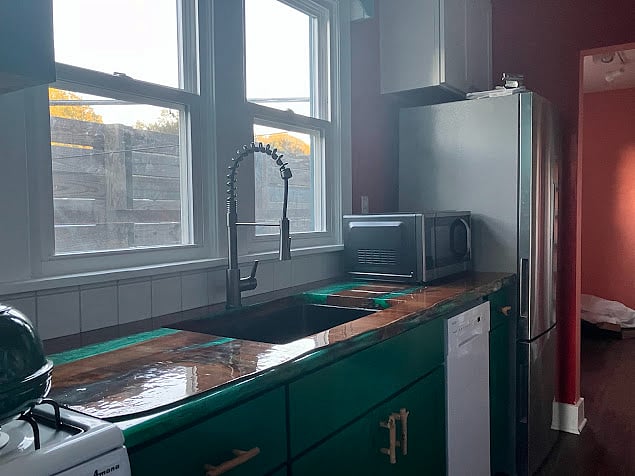 Full kitchen has a refrigerator, microwave, dishwasher, large sink with garbage disposal, and a four burner gas stove with oven.