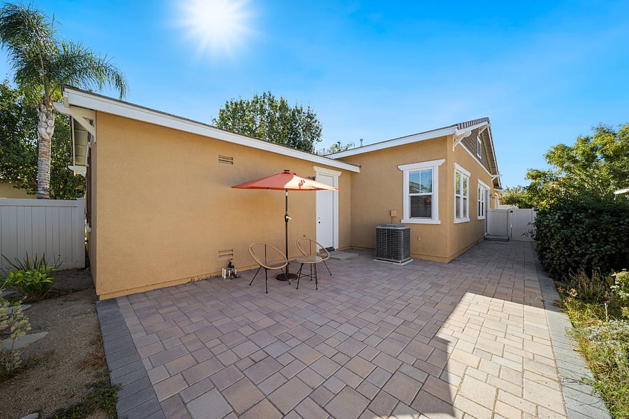 Backyard with dining area & solar lighted umbrella.