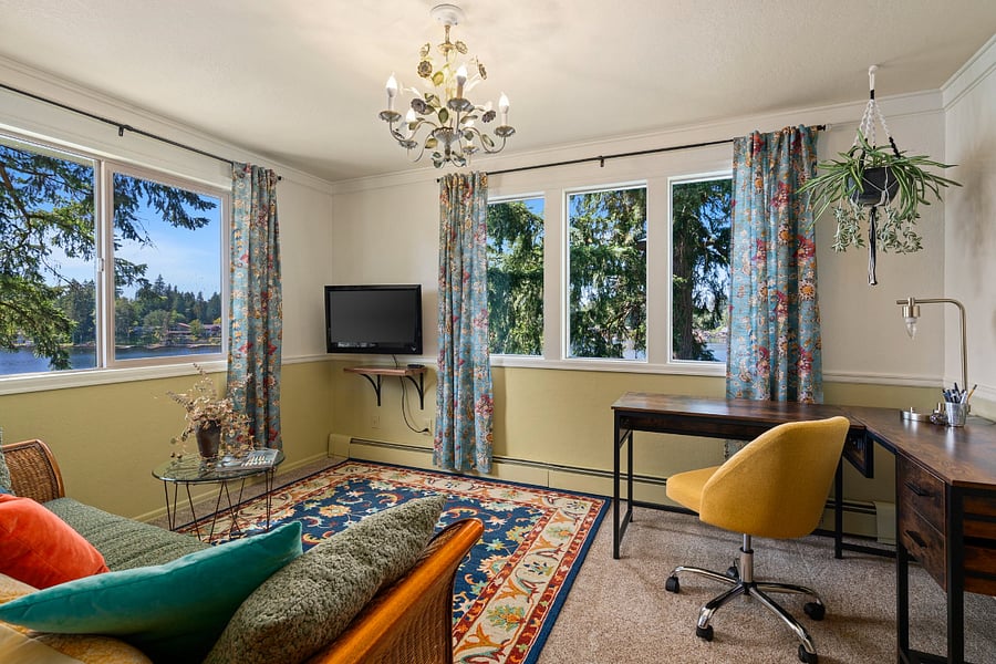 Lounge area with desk, TV, microwave, countertop fridge and freezer, coffee maker