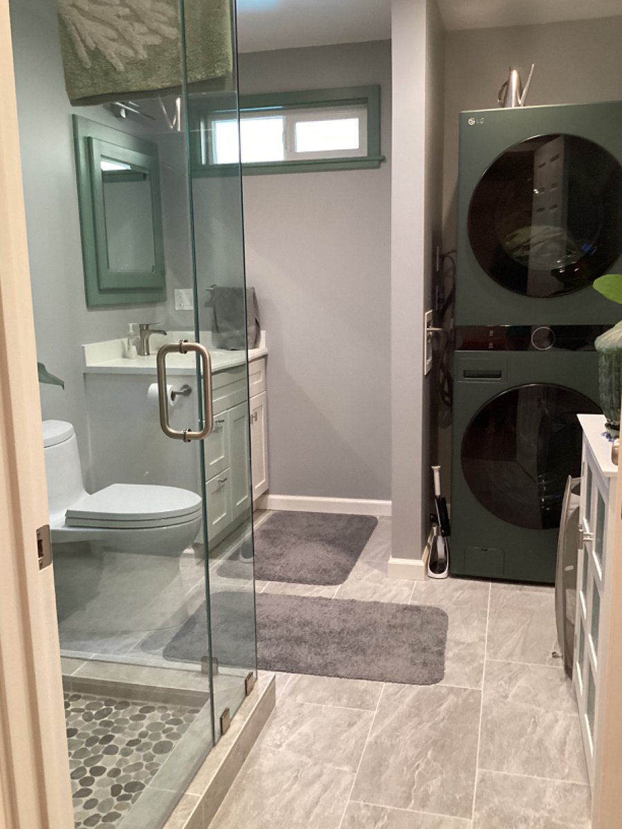 Washer/dryer in bathroom with heated tile floor.